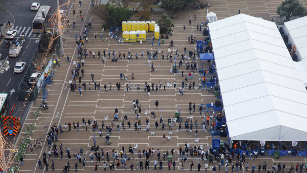 People queue outside a COVID-19 mass vaccination centre at Rabin Square in Tel Aviv.