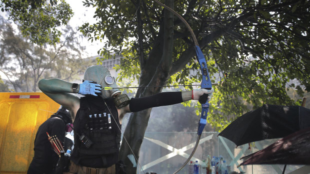 A protester prepares to fire a bow and arrow during a confrontation with police at Hong Kong Polytechnic University.