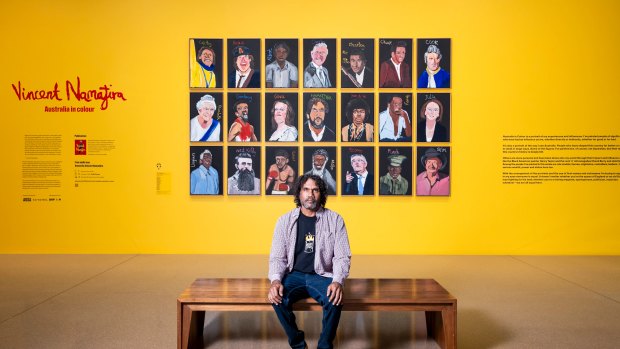 Vincent Namatjira in front of his collection of portraits including  Gina Rinehart.