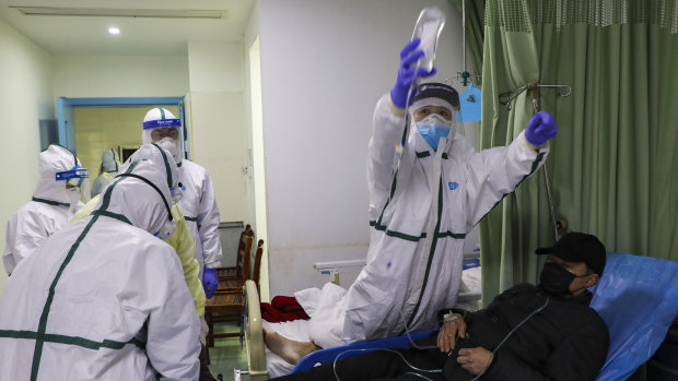Medical workers move a man into the isolation ward for coronavirus patients at a hospital in Wuhan.