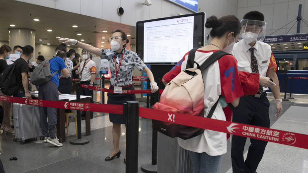 Airline employees directing travellers at the check-in in Beijing: The country's aviation regulator recommends stepping up COVID-19 safety regulations further on board.