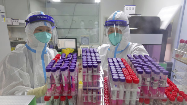 Workers handle swab samples for COVID-19 test at a hospital lab in Yantai in eastern China’s Shandong province in August. 