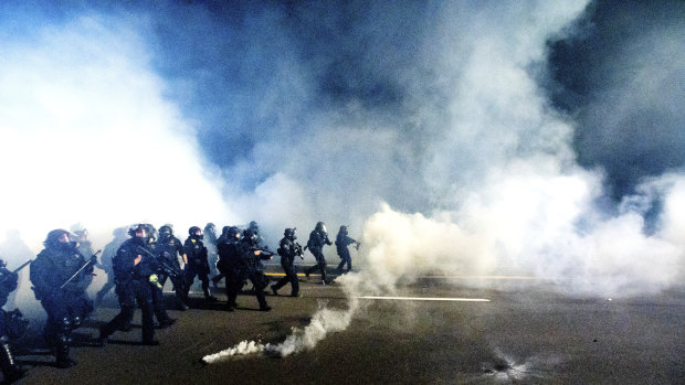 Police use chemical irritants and crowd control munitions to disperse protesters during a demonstration in Portland, Oregon. 