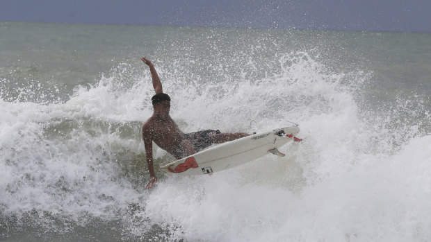 Abu Dzar Al-Ghifari surfs at Carita beach, Indonesia, despite the expanded exclusion zone.