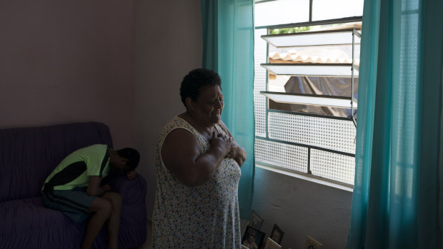 Malvina Firmina Nunes cries as she prays for her missing 35-year-old son Peterson Nunes Ribeiro at home in Brumadinho.