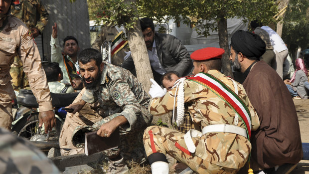  Iranian armed forces members and civilians take shelter from the  shooting in September.