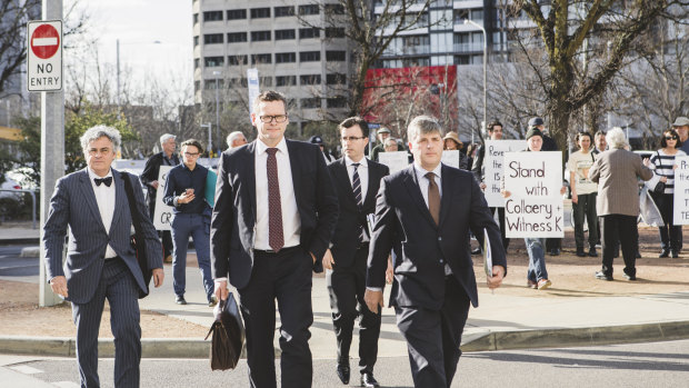 Witness K's lawyer Haydn Carmichael (far left) and Mr Collaery's barrister (far right) pass protesters as they arrive at court on Wednesday.