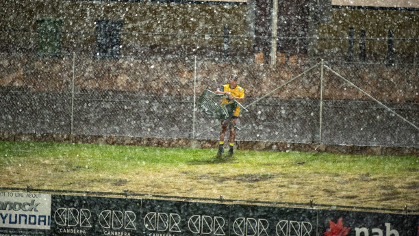 A lone spectator packs up his chair in the rain at Seiffert Oval on Thursday night. 