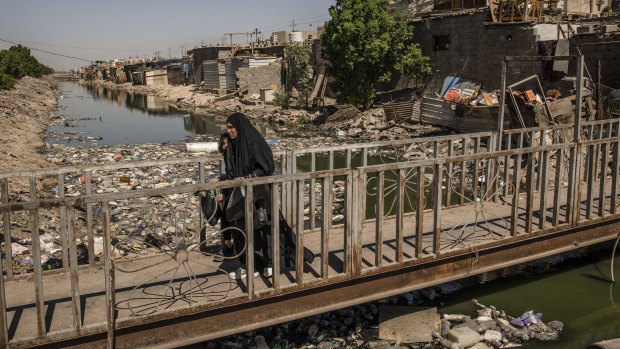 A garbage-strewn canal in Basra, Iraq, show the years of neglect.