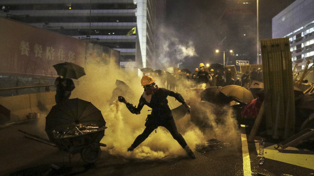 A protester throws a tear gas canister which was fired by riot police during a protest in Hong Kong on Sunday. 