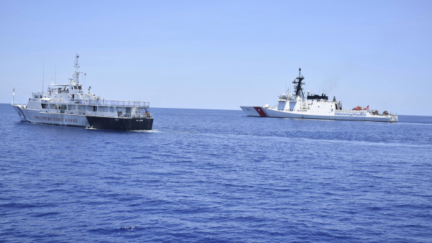 A US Coast Guard vessel, right, and a Philippines counterpart conduct joint exercises west of the Philippines last year.