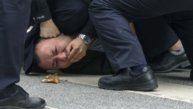 Polis Pazar günü Şanghay'da bir sokakta bir protestocuyu kıstırdı.