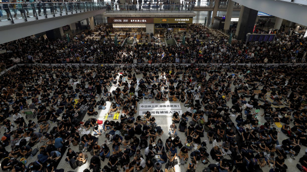 China's efforts to depict the protests as small and violent are at odds with reality. Here, hundreds of protesters stage a peaceful sit-in at the Hong Kong airport on Monday.