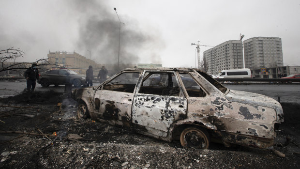 A car, which was burned after clashes, is seen on a street in Almaty, Kazakhstan.