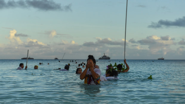 Locals demonstrate traditional fishing practice to round up fish to be cooked on an umu (traditional earth oven) by the lagoon in Funafuti, Tuvalu, on Thursday.