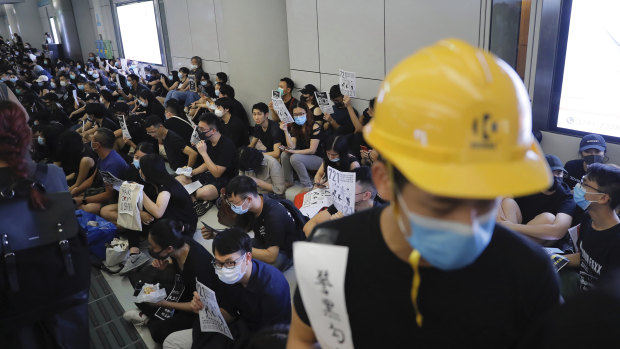 Demonstrators sit during a protest at the Yuen Long MTR station, where demonstrators and others were violently attacked by men in white T-shirts following an earlier protest in July.