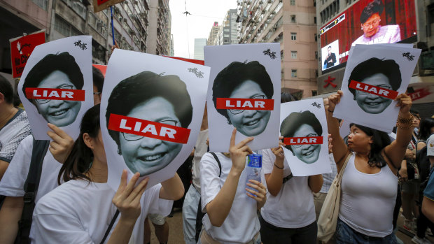 Protesters hold pictures of Hong Kong Chief Executive Carrie Lam as protesters march along a downtown street against the proposed amendments to the  extradition law.
