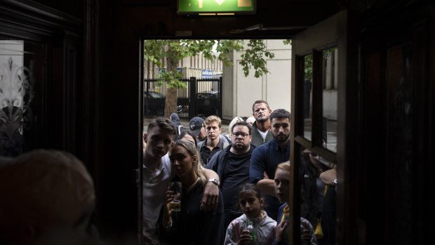 Kalabalıklar, Kral'ın ilk konuşmasını izlemek için Londra'daki bir barın önünde toplanır.