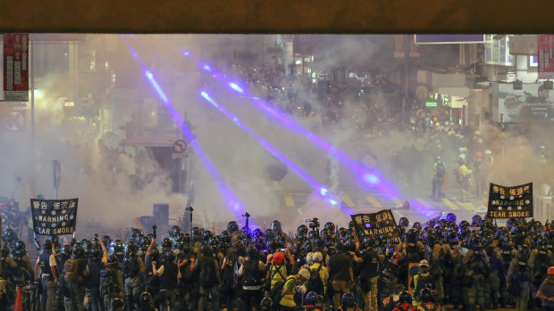 Riot policemen firing tear gas to protesters on a street during the anti-extradition bill protest in Hong Kong.