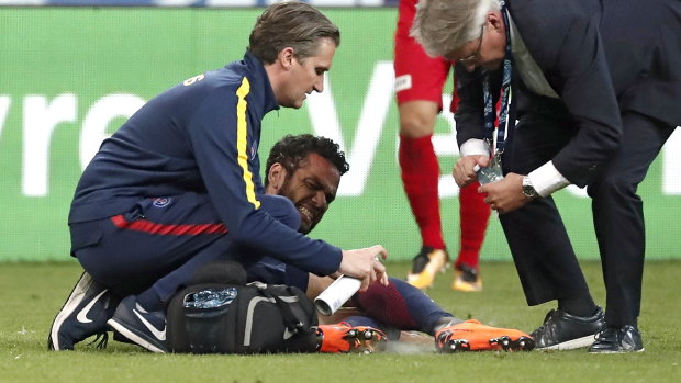 On the shelf: Dani Alves receives treatment during the French Cup final.