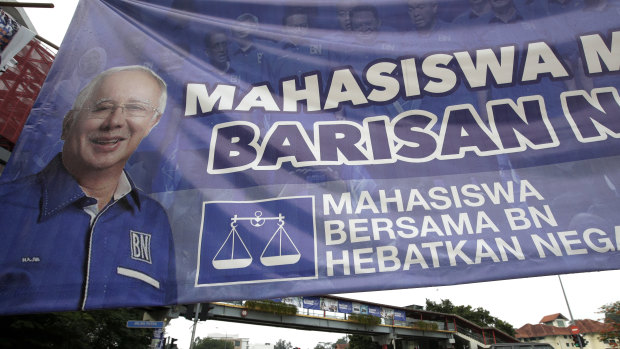 Vehicles pass by a campaign poster of defeated Najib Razak on display along a street in Kuala Lumpur.