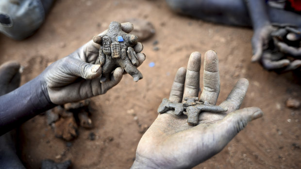 A displaced child holds clay model toys of a peacekeeper and a rifle, in the United Nations camp for displaced people in the capital Juba, South Sudan.