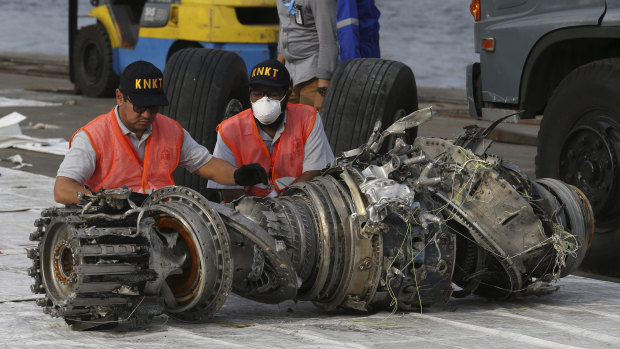 Officials inspect an engine recovered from the crashed Lion Air jet on Monday in Jakarta, Indonesia.