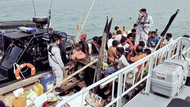 Malaysian navy officers detain a boat carrying Rohingya migrants off Langkawi, Malaysia, last week.