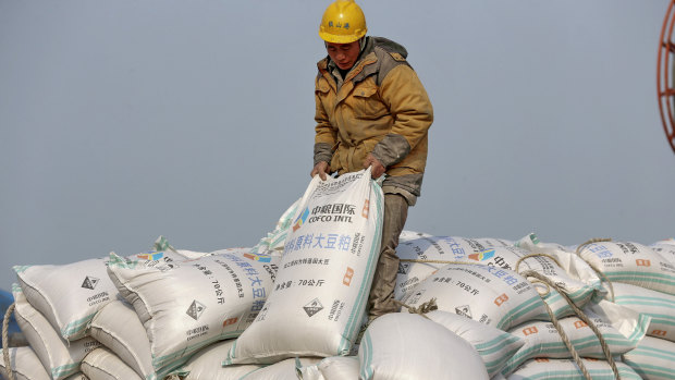 A worker in China's Jiangsu province unloads soy beans, one of hundreds of products to be slapped with tariffs.