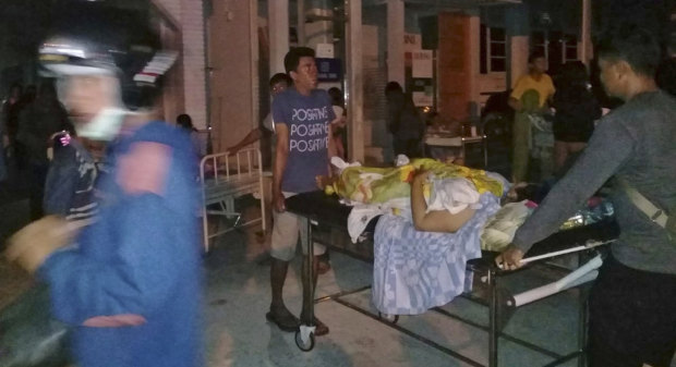 A patient is evacuated from a hospital after the earthquake hit Poso on the island of Sulawesi on Friday.