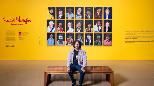 Vincent Namatjira in front of his collection of portraits including  Gina Rinehart.