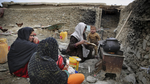 An Afghan family cooks food out in the open at a camp for internally displaced people in Kabul, Afghanistan, on Monday.