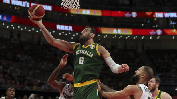 Andrew Bogut of Australia puts up a shot over Amath M'Baye, left, and Evan Fournier of France.