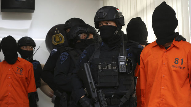 Indonesian Special Detachment 88 anti-terror police unit escorts terror suspects during a press conference at in Jakarta on Friday.