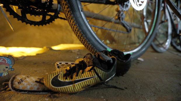 A pair of soccer boots lie next to bicycles from a group of missing boys at the entrance of a deep cave in Chiang Rai, northern Thailand.