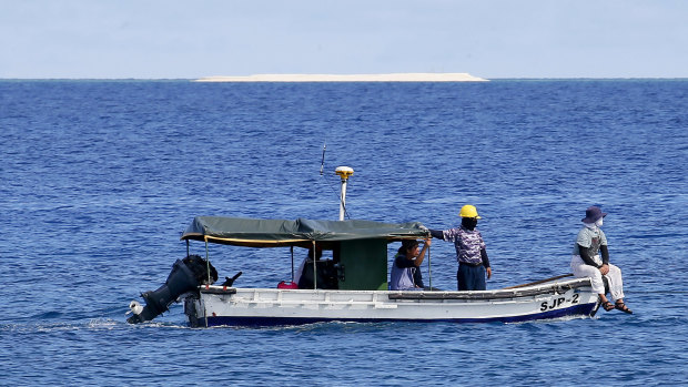Engineers from the Philippine government survey the area around the Philippine-claimed Thitu Island in the disputed South China Sea.