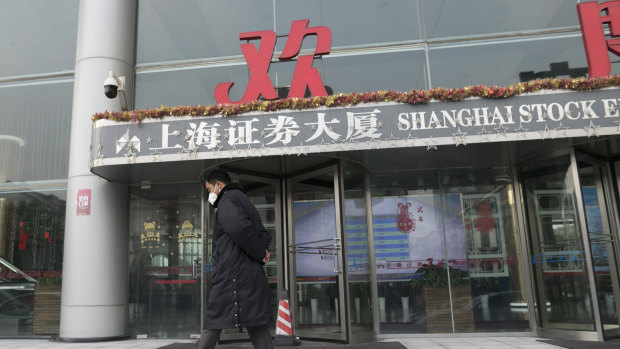 A security officer wearing a face mask walks in front of the Shanghai Stock Exchange building in Shanghai on Monday. The benchmark index dived almost 9 per cent as it re-opened after a 10-day break for Chinese New Year.