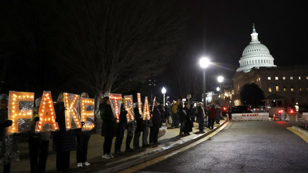 Demonstrators hold signs outside the Capitol in Washington.