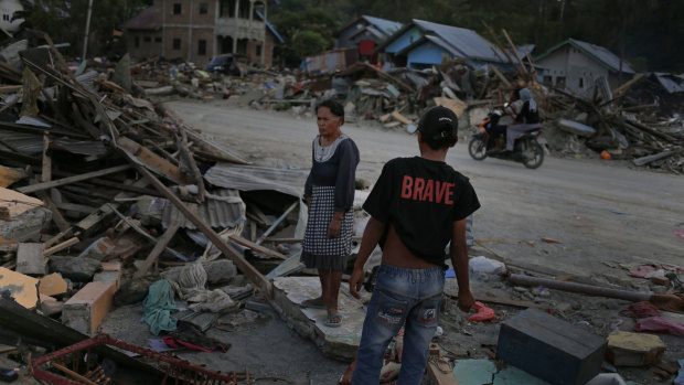 Residents view their destroyed home in their village heavily damaged by Friday's tsunami in Palu.