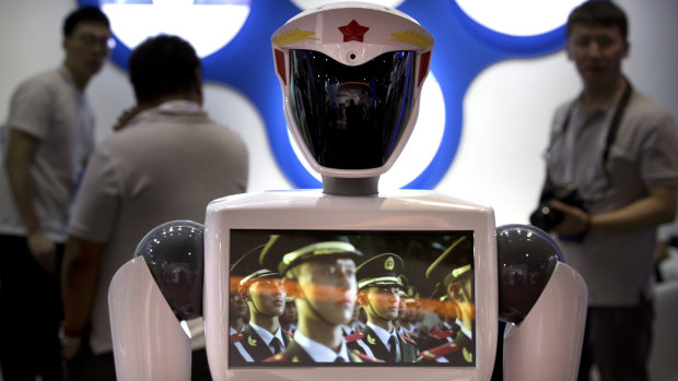 Chinese People's Liberation Army soldiers play in a video on the chest screen of a robot from Chinese robot maker Jiangsu Eastern Golden Jade Intelligent Robot Co.