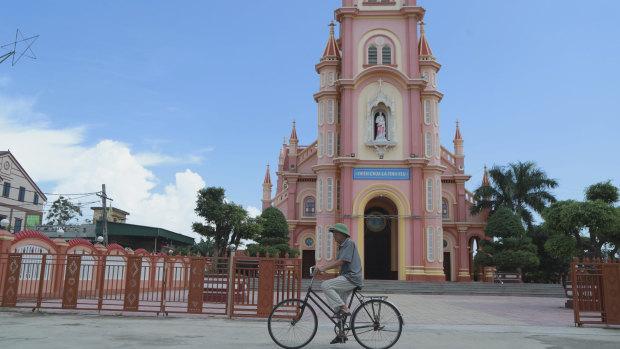 A man rides his bicycle past a Catholic church in the Dien Thinh village from where many of the victims came from.