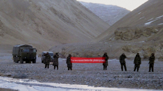 Chinese troops hold a banner which reads "you've crossed the border, please go back" in Ladakh, India, in 2013.