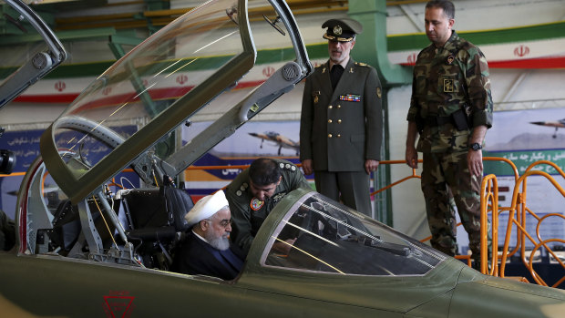 Iranian President Hassan Rouhani is briefed by an air force pilot as he sits in the cockpit of a fighter jet, before an inauguration ceremony of the aircraft in Iran on Tuesday.