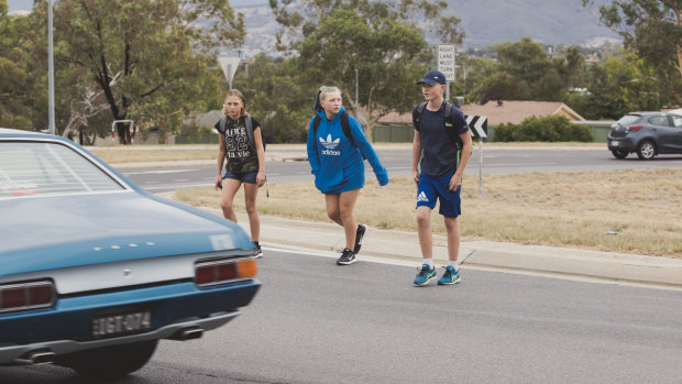 Cerys, left, Rhiannon and Harry, crossing the busy roundabout at the intersection of Erindale Drive and Sternberg Crescent.