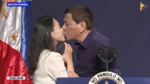 President Rodrigo Duterte leans in to kiss a Filipino worker during a townhall-style meeting with overseas Filipino workers in Seoul.