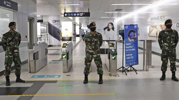Soldiers stand guard at an MRT station in Jakarta, Indonesia.
