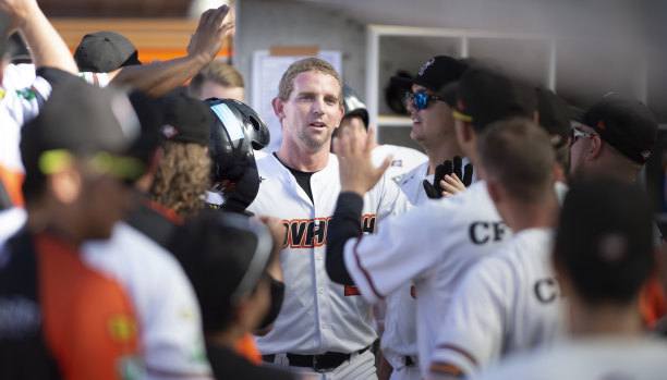 Canberra Cavalry's David Kandilas celebrates his home run in the dugout.