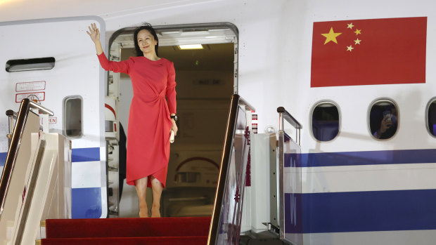 Meng Wanzhou waves as she steps out of an airplane in Shenzhen.