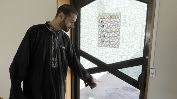 Khaled Alnobani gestures as he explains his escape through a glass door panel. He thinks as many as 17 people may have died trying to get out through the door.