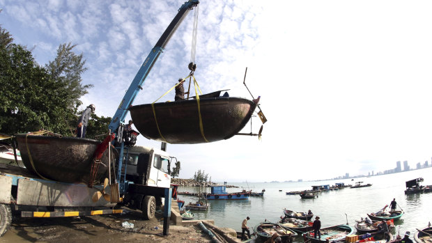 People move fishing boats to a safer place ahead of the arrival of typhoon Molave in Danang, Vietnam.